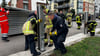 Mit geübten Handgriffen bauen die Feuerwehrleute die mobile Hochwasserschutzwand an der Elbe in Magdeburg auf.
