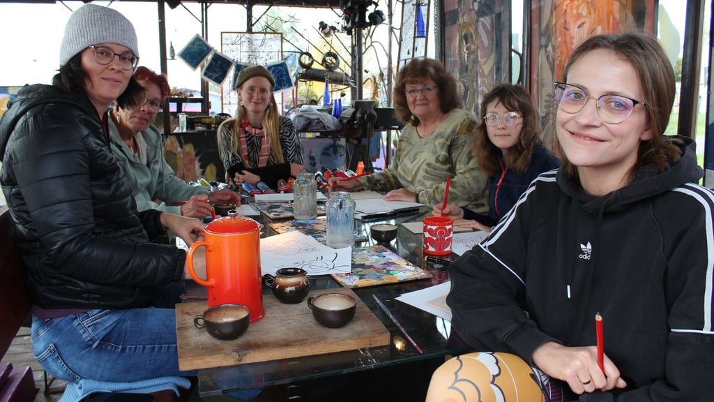 Beim Malerei-Kurs auf dem Kunstschiff „Salon Walter“ sitzen die Teilnehmerinnen gemeinsam am Tisch und zeichnen außergewöhnliche Motive auf Holz-Leinwände.