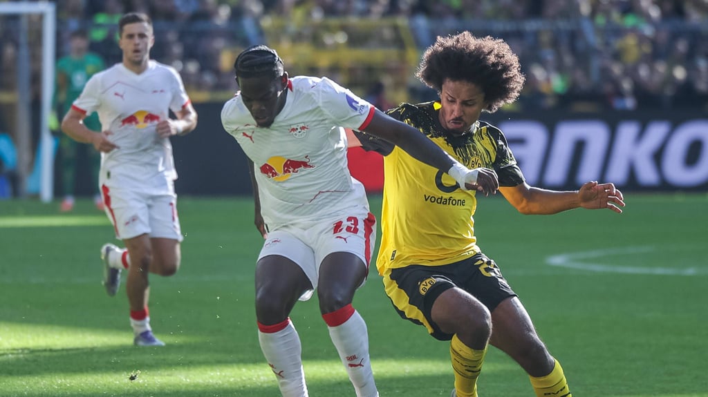 Castello Lukeba (l.) beim RB-Spiel in Dortmund im Zweikampf mit Karim Adeyemi.