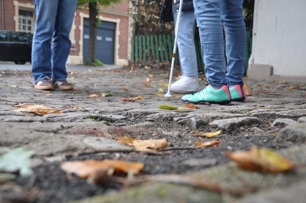 Pflastersteine und Löcher im Gehweg machen es Rollstuhlfahrern und Menschen mit einer Sehbehinderung schwer.