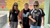Ganz blind (links) und zu einem Großteil blind (rechts) lassen sich zwei Schülerinen von einer Mitschülerin über das Schulgelände führen.