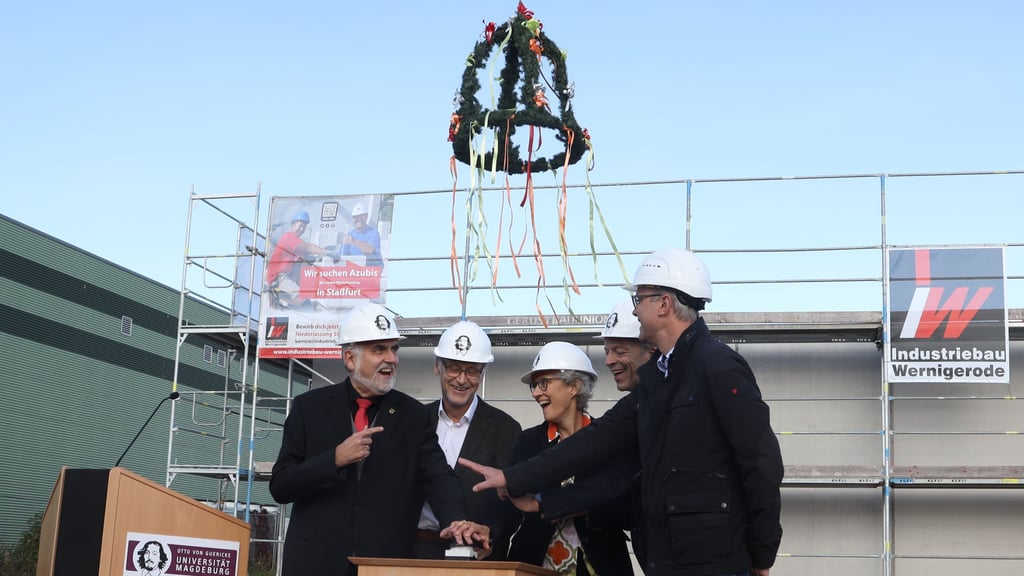Wissenschaftsminister Armin Willingman, Uni-Rektor Jens Strackeljan, Manuela Schwartz (Rektorin Hochschule Magdeburg Stendal), Folker Roland (Rektor Hochschule Harz) und Michael Truthmann, Geschäftsführer Industriebau Wernigerode (von links), sorgen per Knopfdruck für das Hissen der Richtkrone.