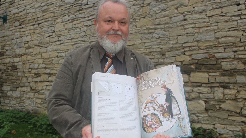 Vor historischen Mauern gewährt der Oschersleber Künstler Kay Elzner einen Blick in das Buch über Kleidung der Renaissance.