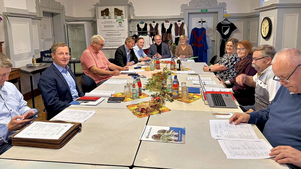 Der Schirmherr des Zahnaer Jubiläums-Stadtfestes 2026, Reiner Haseloff, gemeinsam mit der Festkomitee-Vorsitzenden Helga Gresse im Gespräch mit Komiteemitgliedern