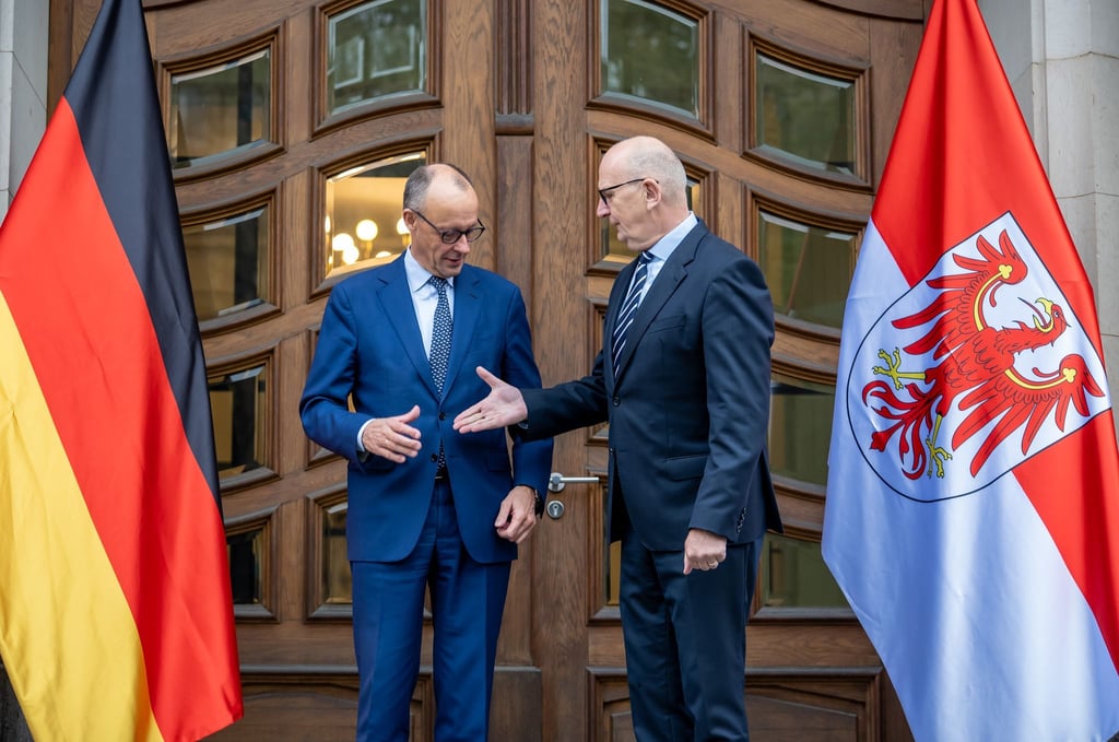 „Shake hands“ zum Auftakt: Kanzler Merz (CDU) wird vom brandenburgischen Ministerpräsidenten Dietmar Woidke (SPD) empfangen. Es ist der erste offizielle Antrittsbesuch des Kanzlers in einem ostdeutschen Bundesland.