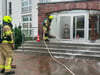 Feuerwehrleute beim Reinigen eines der Klinikeingänge.