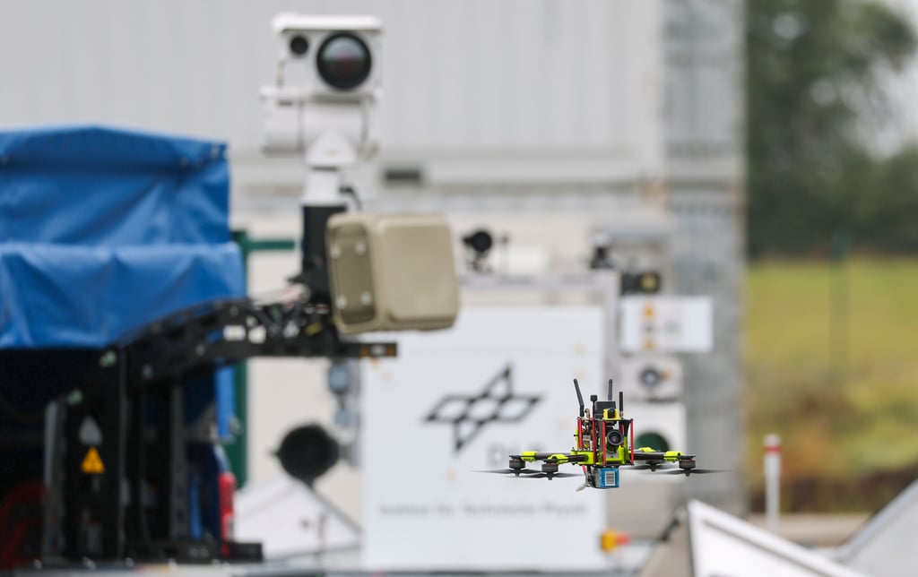 Eine Drohne fliegt vor einem Flybot-Detektionssystem mit Radar und Wärmebildkamera des Deutschen Zentrums für Luft- und Raumfahrt auf dem Flughafen Cochstedt.