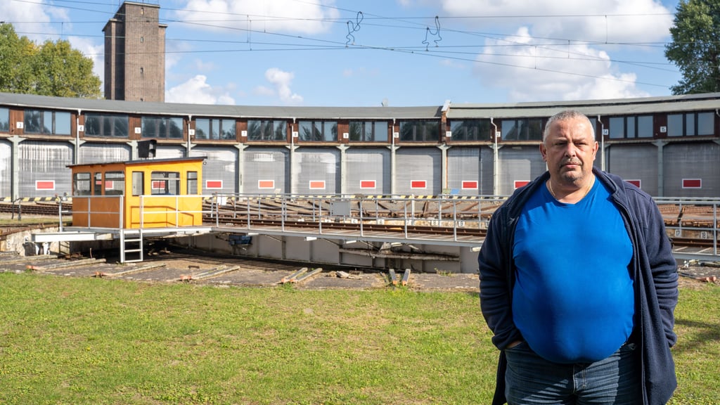 Vor dem mächtigen Rund des alten Ringlokschuppens in Wittenberg steht Michael Jungfer, die Hände in den Taschen, der Blick ernst.