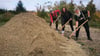 14 Tonnen Sand und drei engagierte Magdeburger: Gert Müller (von rechts), Beate Handschak und Markus Schlüter bereiten den neuen Boule-Platz vor – mit Schippe und Sand fürs Savoir-vivre.