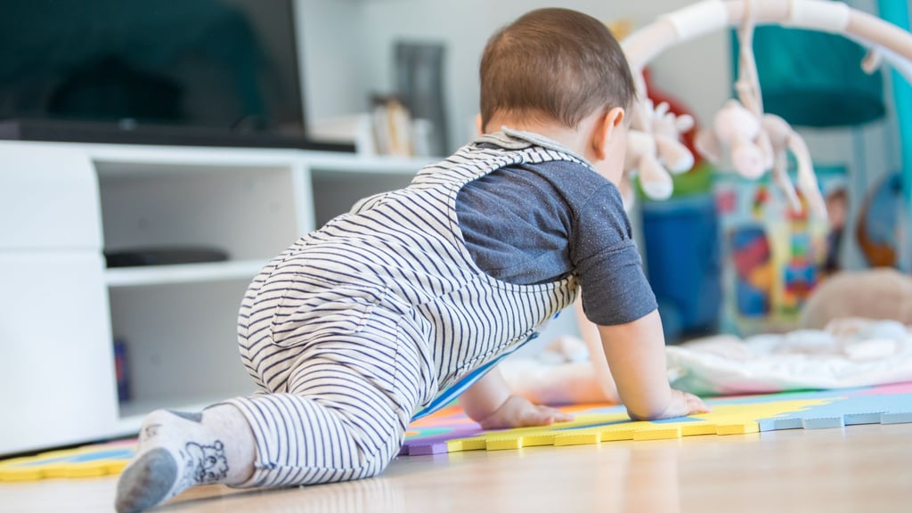 Krabbeln und entdecken: Häufiges Staubsaugen und feuchtes Wischen hilft, Babys vor im Hausstaub lauernden Schadstoffen zu schützen.