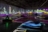 Beim Spiel BattleRace wird die Halle zur echten Mario-Kart-Arena: Die Fahrer jagen über die projizierte Strecke, feuern Raketen ab und weichen virtuellen Ölfässern aus.