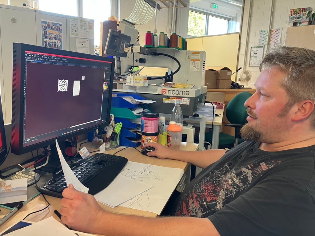 Nils Dönau arbeitet in der Buchbinderei der Lebenshilfe Mansfelder Land in Eisleben und gestaltet am PC Flyer und Werbematerialien.