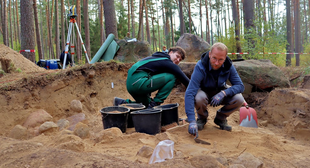 Am Großsteingrab I bei Immekath führt ein Team um Carlo Danneberg (links) und Nick Kirchhoff zurzeit archäologische Untersuchungen durch. Zwischen ihnen im Hintergrund ist der im Mai 2024 gestohlene Stein zu sehen. Er ist zurück am Großsteingrab.