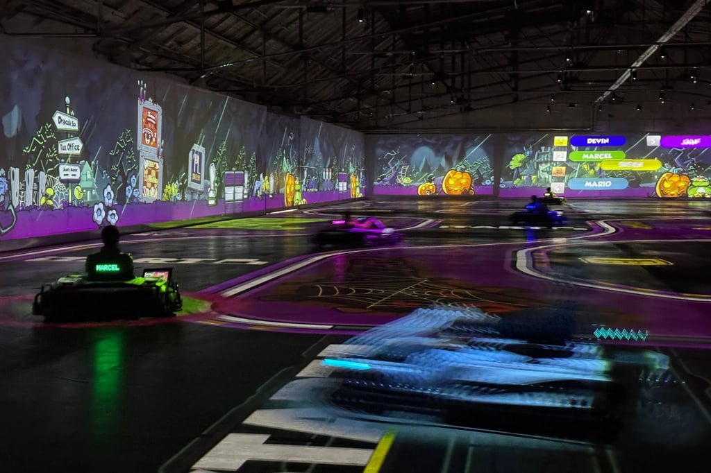 Beim Spiel BattleRace wird die Halle zur echten Mario-Kart-Arena: Die Fahrer jagen über die projizierte Strecke, feuern Raketen ab und weichen virtuellen Ölfässern aus.