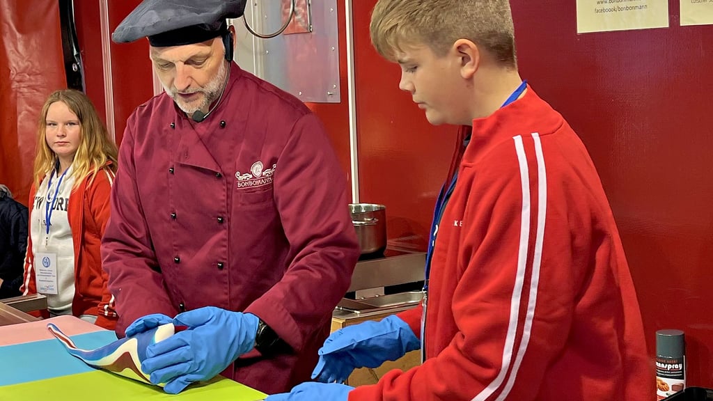 Bonbonherstellung zum Anschauen beim Zeitzer Zuckerfest: Bonbonmann Dirk Lawrenz präsentierte sein süßes Handwerk und hatte fleißige Helfer aus der Sekundarschule Am Schwanenteich, die mit ihrem fleißigen Einsatz die Spendenkasse der Schule füllen.