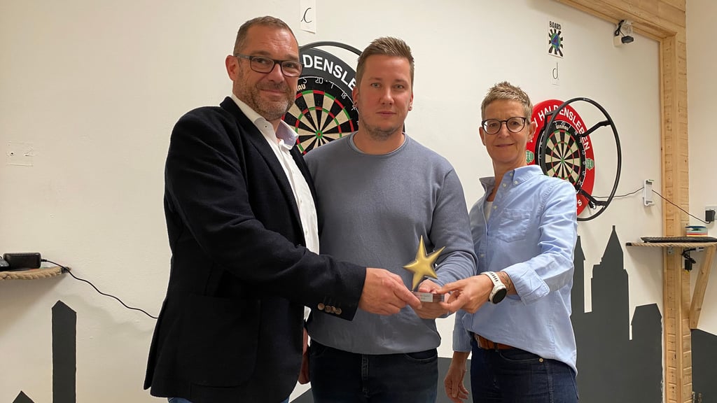 Tim Teßmann (Mitte) nimmt den bronzenen Stern für den Handballsportverein Haldensleben HSV von Andreas Jung und Simone Baars aus der Volksbank entgegen.