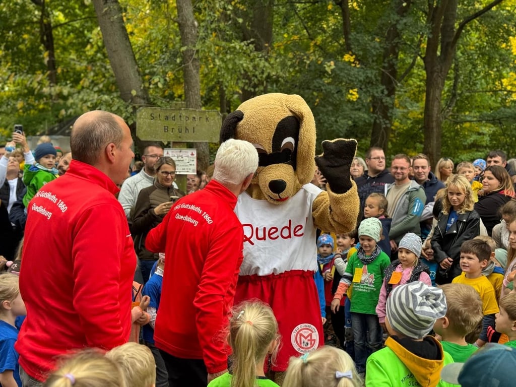 Darf beim Herbstlauf in Quedlinburg nicht fehlen: Maskottchen Quedel, das hier durch die Kinder, Eltern und Großeltern sowie Frank Müller und Konrad Sutor von der TSG GutsMuths begrüßt wird.