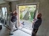 Marcus Rausch, Jeannine Kanitz und Christopher (von links) von der Alekra Sanierungsfachbetrieb GmbH aus Thale beim Einsetzen eines Türrahmens im Erdgeschoss des künftigen Kinderschutzhauses in Blankenburg.