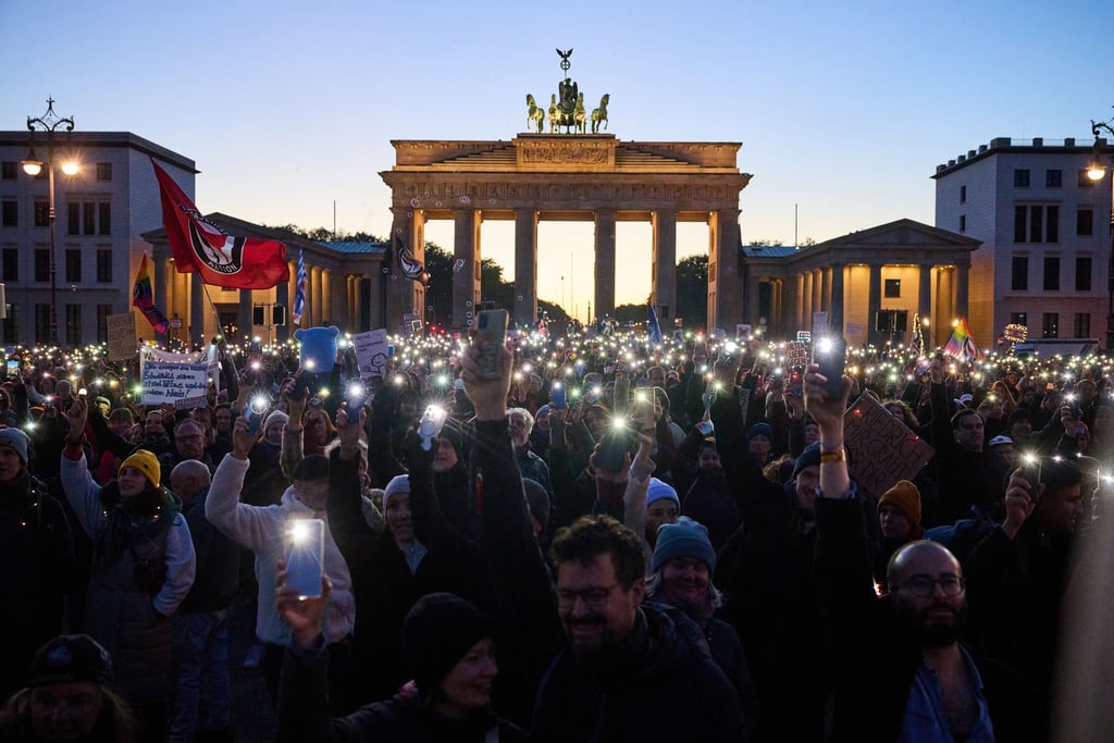 Hunderte Demonstranten bilden mit Smartphones und Feuerzeugen ein Lichtermeer.