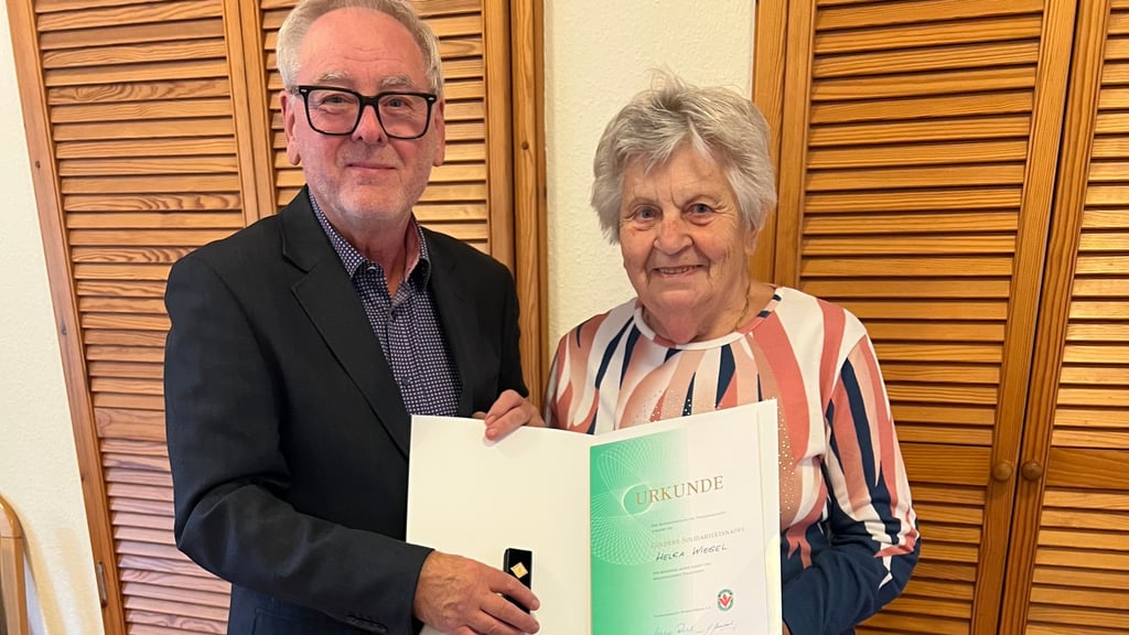 Horst Riethausen überreicht Helga Wiegel die „Goldene Solidaritätsnadel“ in Wanzleben.