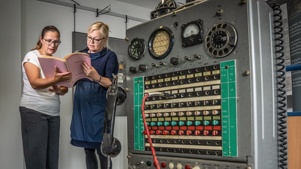 Marit Krätzer (r.), Leiterin der Außenstelle Halle des Stasi-Unterlagen-Archivs, und Archivarin Ulrike Vogel stehen hier vor der alten Telefontechnik.