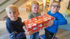 Jakob, Fiete und Emil (von links) mit einem der Päckchen, die nach Osteuropa gehen.