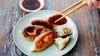 Die mit Schweinefleisch, Kohl, Knoblauch und Ingwer gefüllten Jiaozi gelten als Vorläufer von Teigtaschen wie Gyoza aus Japan oder koreanischen Mandu.