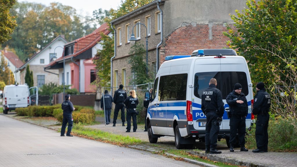 Polizisten stehen vor einem Grundstück in Herzberg.