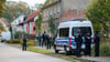 Polizisten stehen vor einem Grundstück in Herzberg.