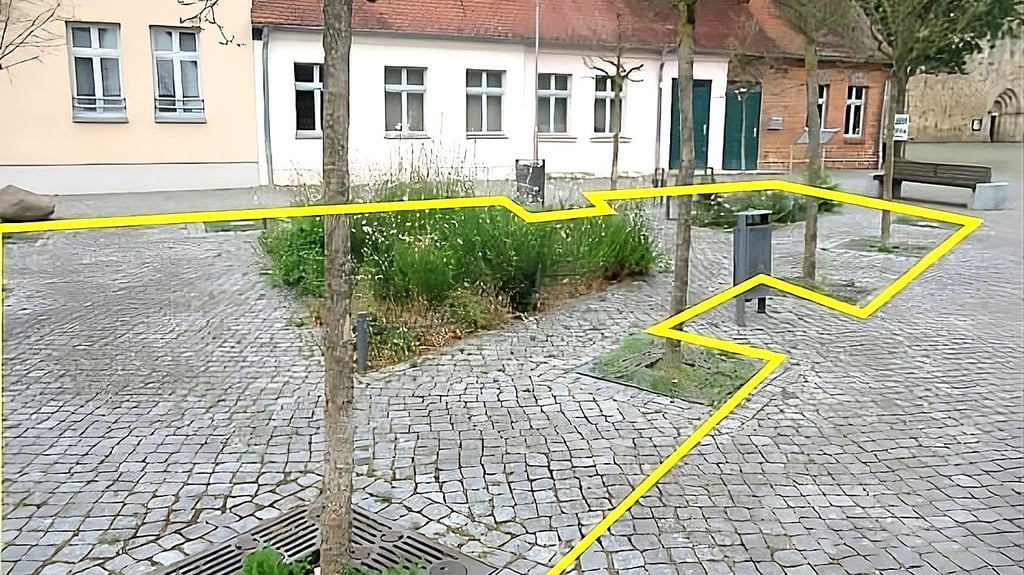 Jella Schnirch und Erik Peretzke haben in Havelberg etliche städtische Flächen ausgemacht, wo das Abpflastern möglich wäre. So wie hier am Platz des Friedens vor den historischen Handwerkerbuden unweit vom Dom.