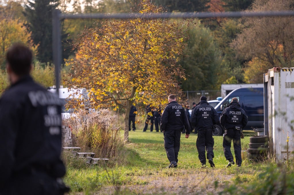 Polizisten stehen bei dem Großeinsatz auf einem Grundstück. (Archivbild)