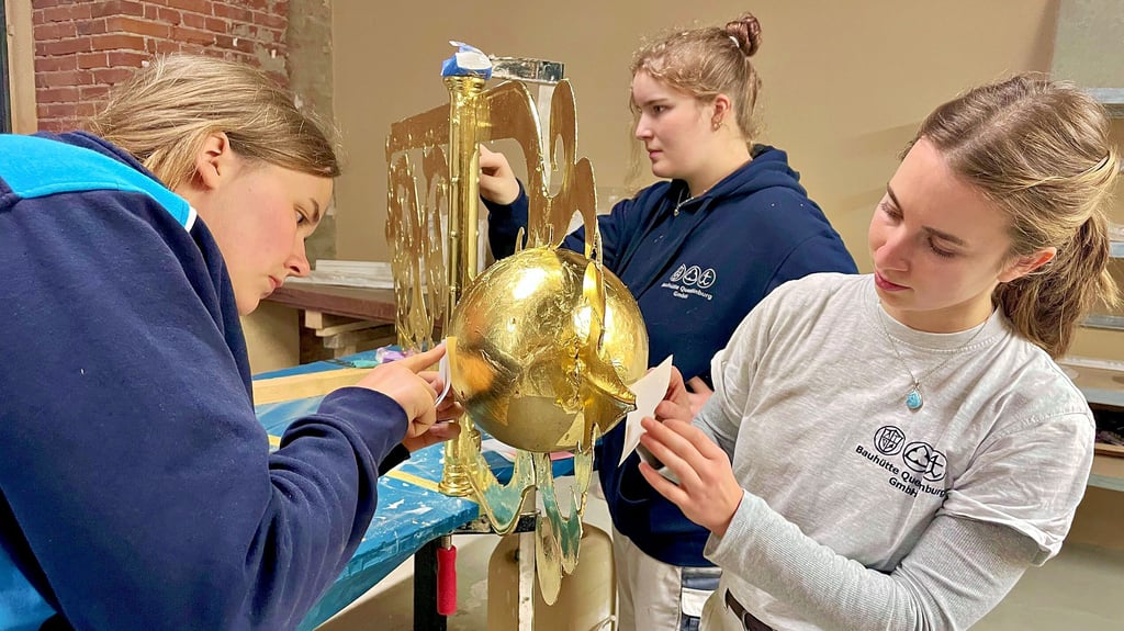 Ein Job mit Verantwortung für Tausende Euro: Paula Spielmeyer (von links), Elisabeth Bauer und Sophie von Morstein tragen hier das Blattgold vom Transparentpapier auf. Langsam und vorsichtig, Millimeter für Millimeter. Erst nach dem Polieren wird die Wetterfahne dann erstrahlen.