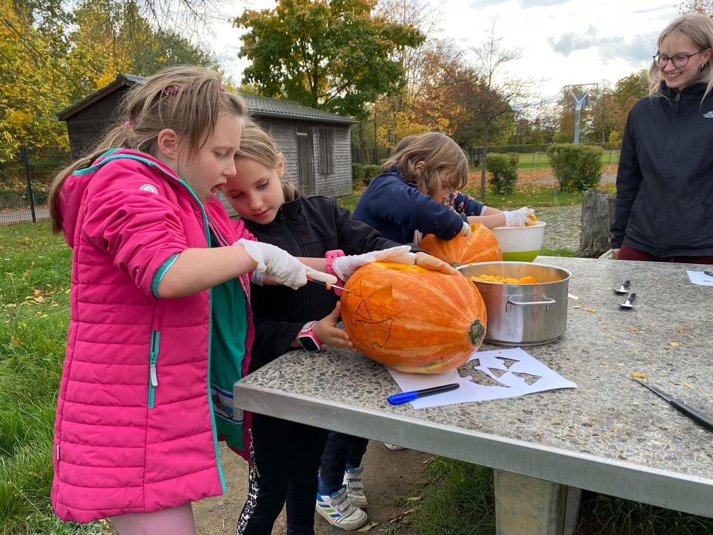 Hochkonzentriert arbeiten die Kinder an den Kürbissen.