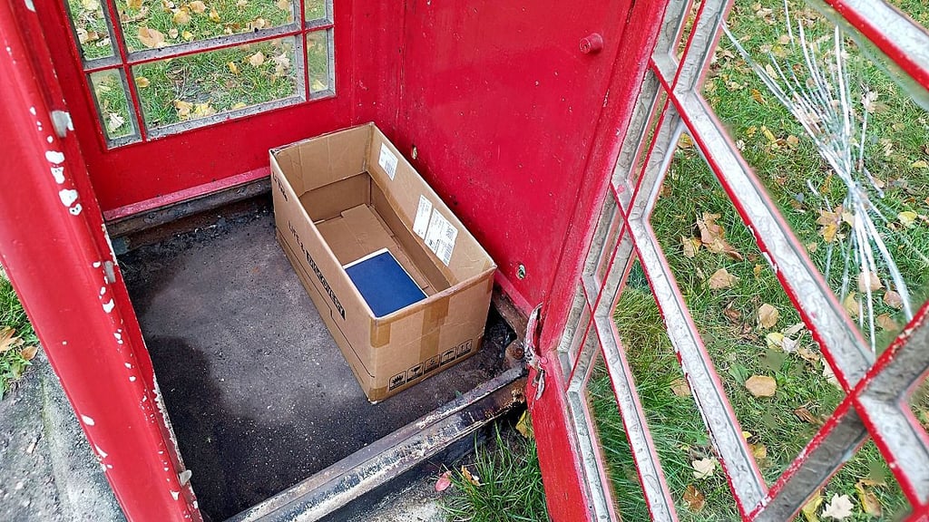 Ausgebrannte Büchertelefonzelle mit einem letzten Buch darin und zerbrochener Fensterscheibe. Die Zelle soll in den kommenden Monaten wieder hergerichtet werden.