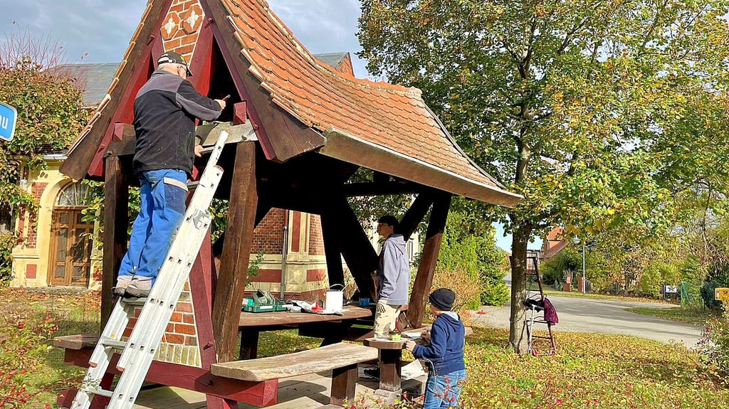 Jonathan und Gabriel Jeschke sowie Lutz und Elke Kadasch haben in Kümmernitz die Frau-Harke-Sitzgruppe mit frischer Farbe versehen.