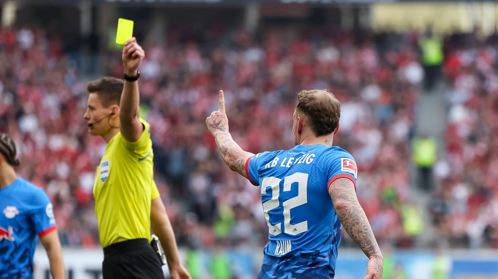 Schiedsrichter Daniel Siebert zeigt RB-Profi David Raum Gelb.