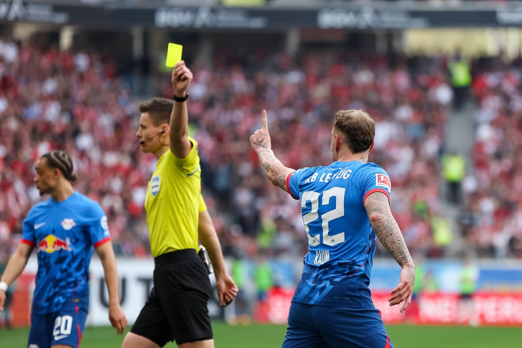 Schiedsrichter Daniel Siebert zeigt RB-Profi David Raum Gelb.