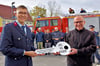 Mark Fischer (parteilos) überreicht Ortswehrleiter Frederic Lorenz (Foto links) den symbolischen Schlüssel für das neue Feuerwehrgerätehaus in Tröglitz.