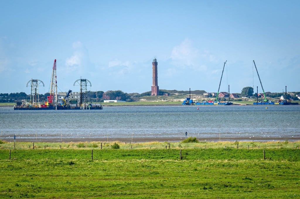 Vom Festland aus ist das Kabelverlegeschiff „Barbarossa“ im Watt vor Norderney zu sehen.