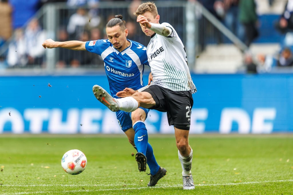 Baris Atik (l, 1. FC Magdeburg) kämpft gegen Jano ter Horst (Preußen Münster) um den Ball.