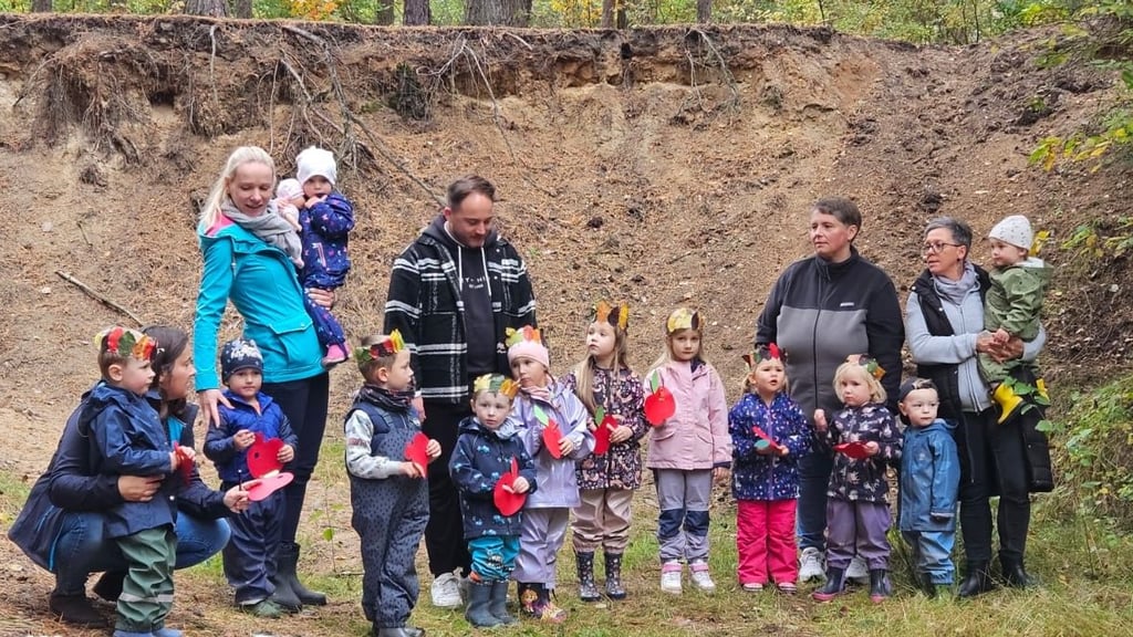 Mit selbst gebastelten Äpfeln und bunten Blätterkronen begrüßen die Mädchen und Jungen der Kita „Eichkätzchen“ ihre Eltern am Waldhang – begleitet von Liedern und Fingerspielen.