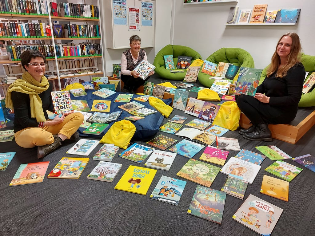 Die beiden Bibliotheksmitarbeiterinnen Sandra Graneist (l.) und Antje Key (r.) sowie Dorothee Sieber, Leiterin der Lesepaten-Initiative des Naumburger Bürgervereins, mit einer Auswahl an Bilderbüchern.