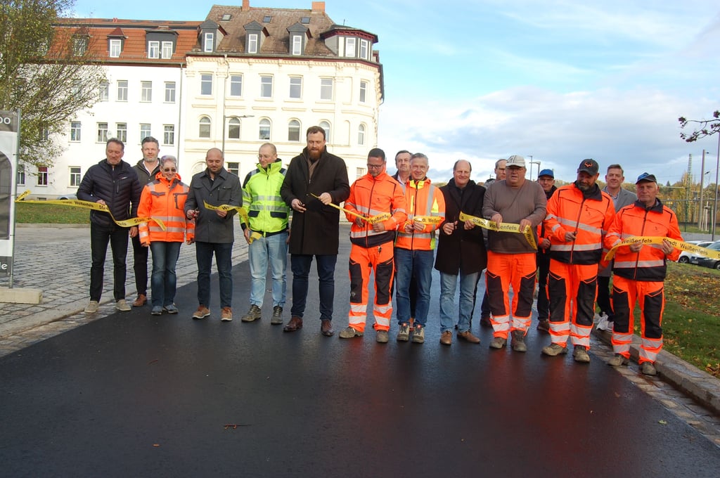 Oberbürgermeister Martin Papke (6. v. l.) hat mit Vertretern von Stadtverwaltung, Baubeteiligten, Planungsbüros und Bauunternehmen das symbolische Band zur Freigabe der Weinbergstraße durchgeschnitten.