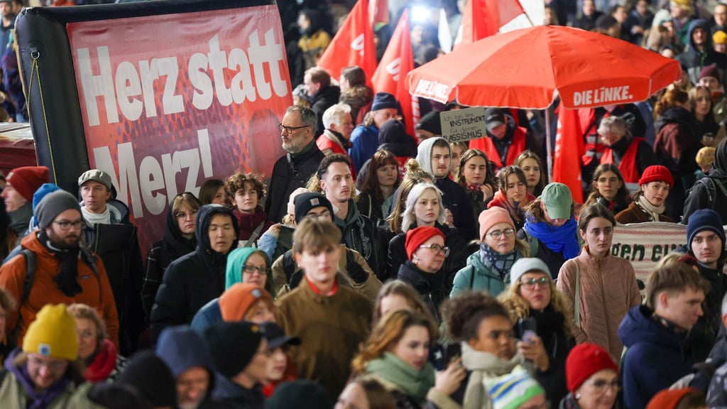 Menschen halten bei der Demo für ein „buntes Stadtbild“ in Leipzig Plakat mit der Aufschrift „Herz statt Merz!“ hoch.