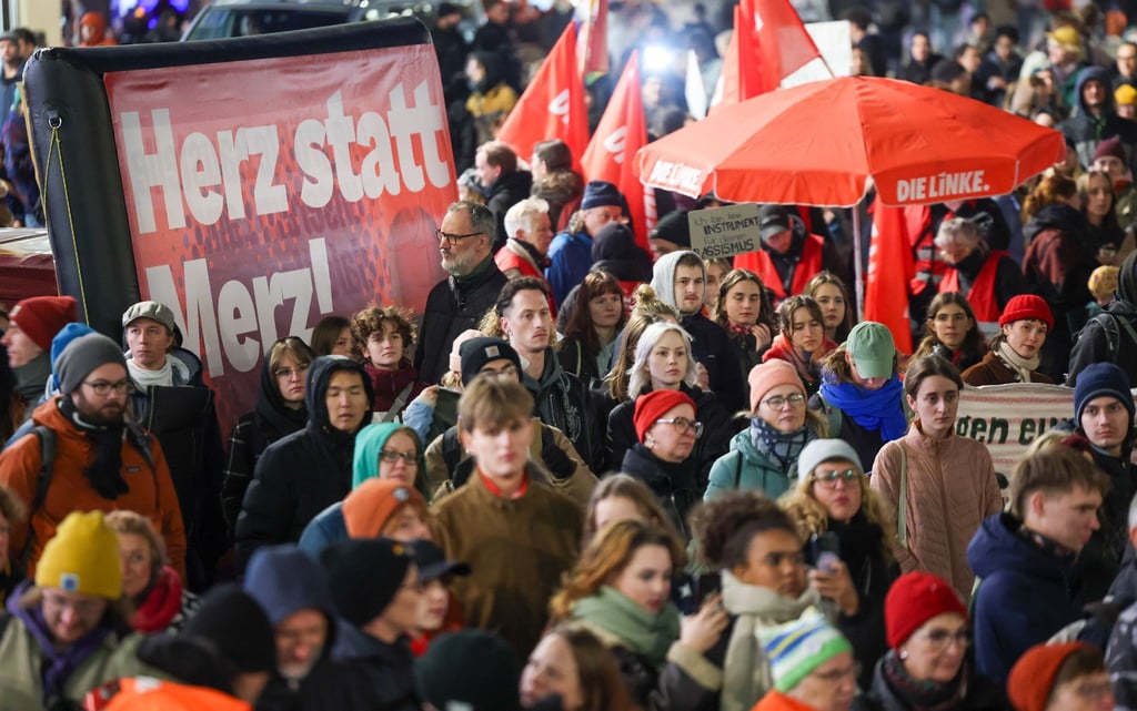 Menschen halten bei der Demo für ein „buntes Stadtbild“ in Leipzig Plakat mit der Aufschrift „Herz statt Merz!“ hoch.