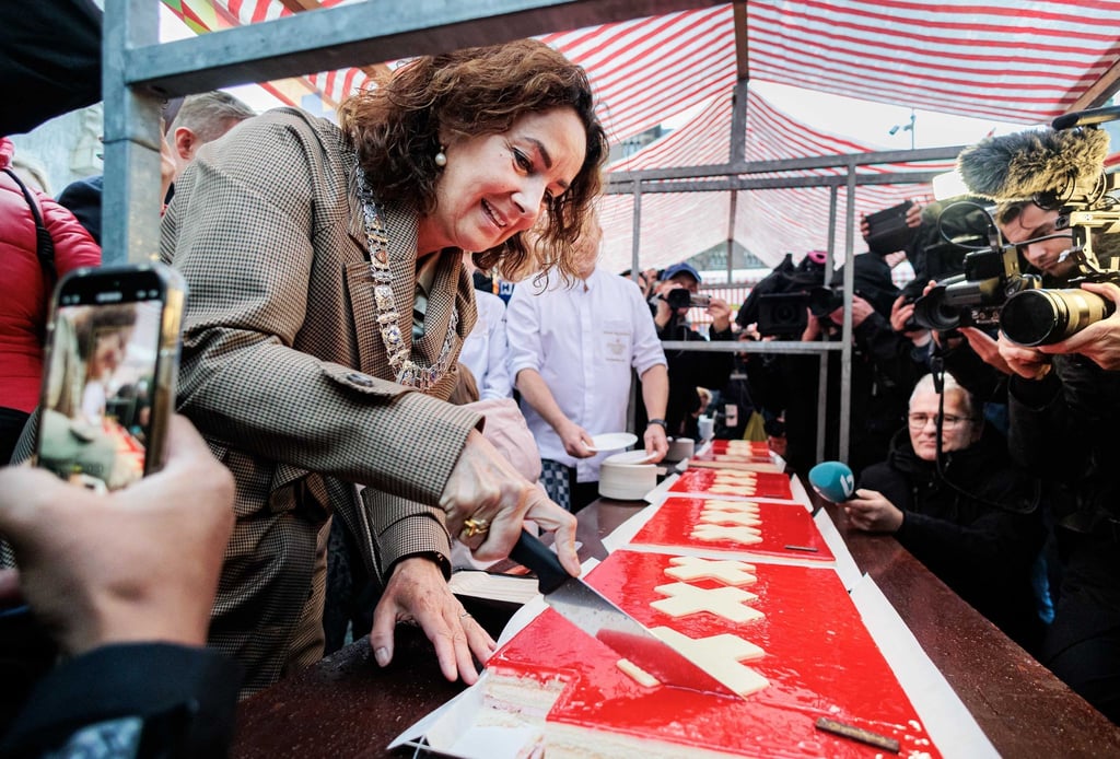 Amsterdams Bürgermeisterin Femke Halsema schneidet die lange Torte an.