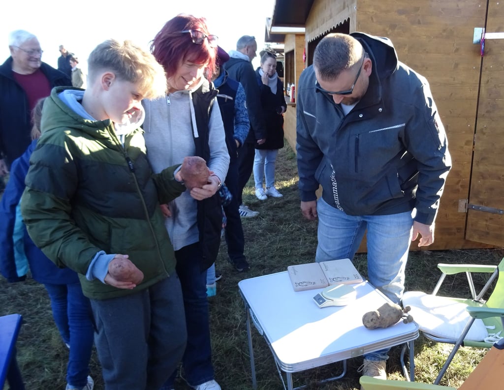 Marvin und Simone Schulze freuen sich über die Auszeichnung für die größte Kartoffel des Festes – und über die eigens gefertigten Königs- und Königinnen-Brettchen als Preis.