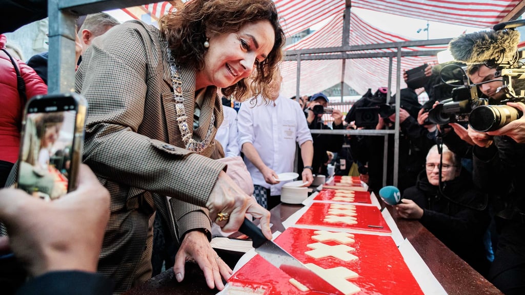 Amsterdams Bürgermeisterin Femke Halsema schneidet die lange Torte an.