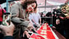 Amsterdams Bürgermeisterin Femke Halsema schneidet die lange Torte an.