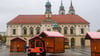 Ein Gabelstapler versetzt auf dem Alten Markt in Magdeburg eine Bude aus Holz.